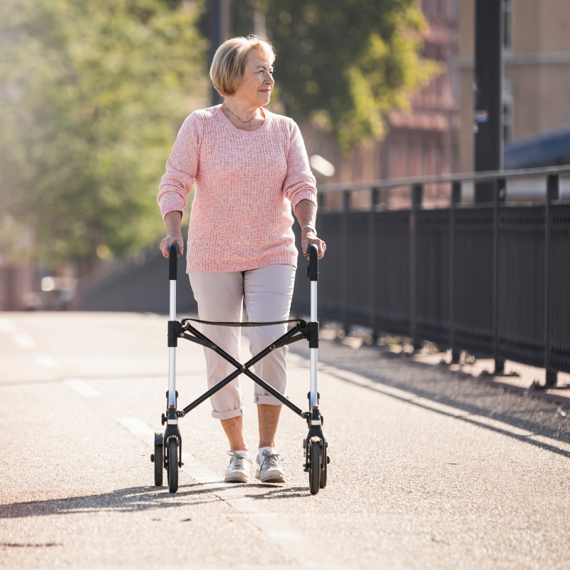 Woman with wheeled walker on footbridge