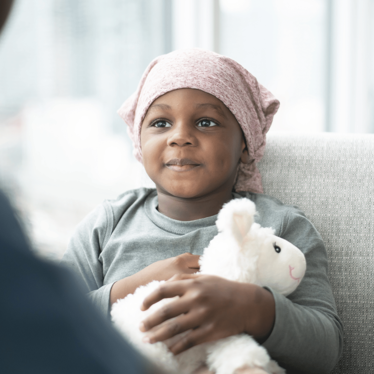 Little African American boy with head wrap and stuffed animal